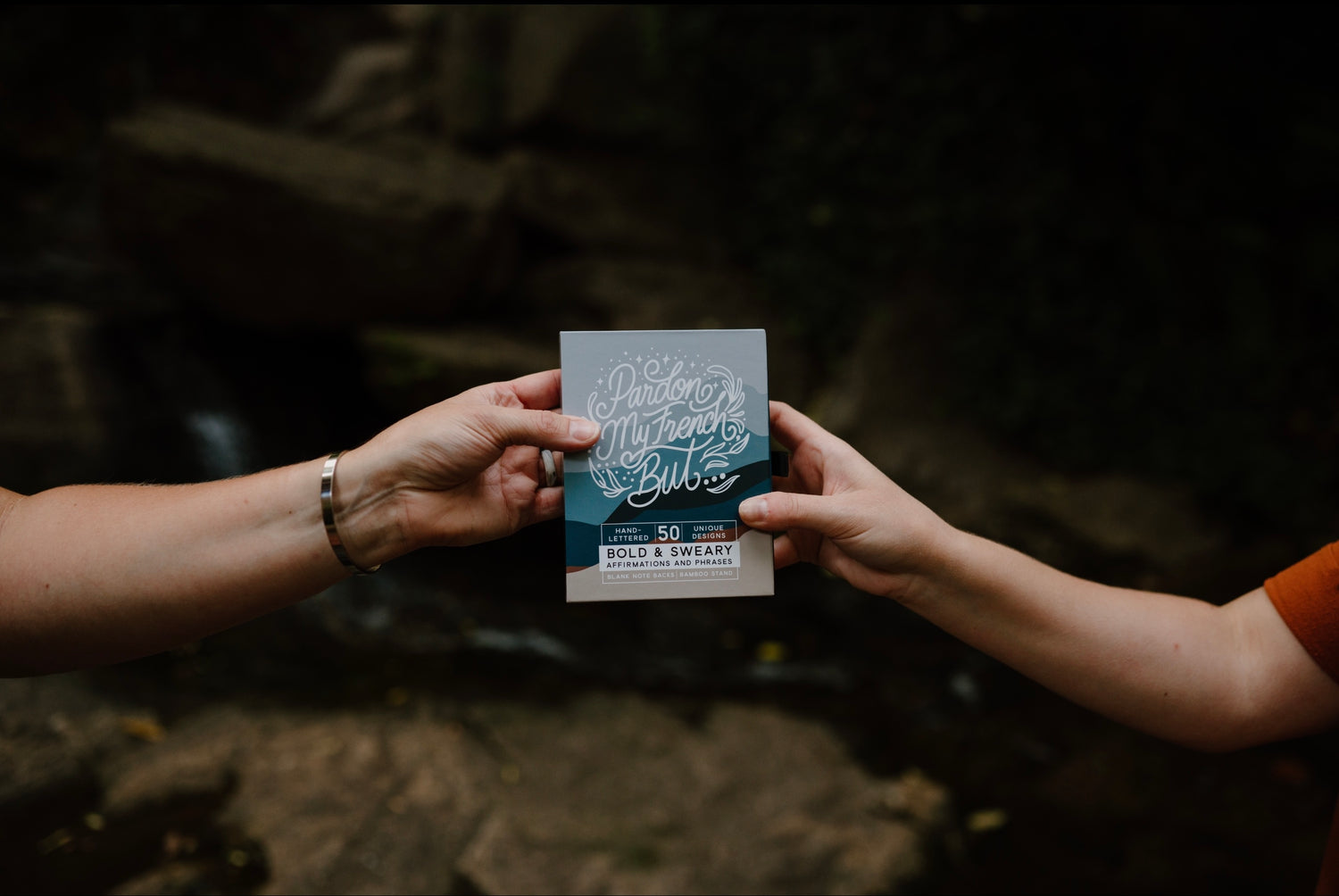 Hand giving gift of affirmation cards to a friend